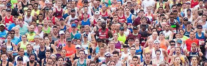 Groups of runners crossing the start line of the Bank of America Chicago Marathon